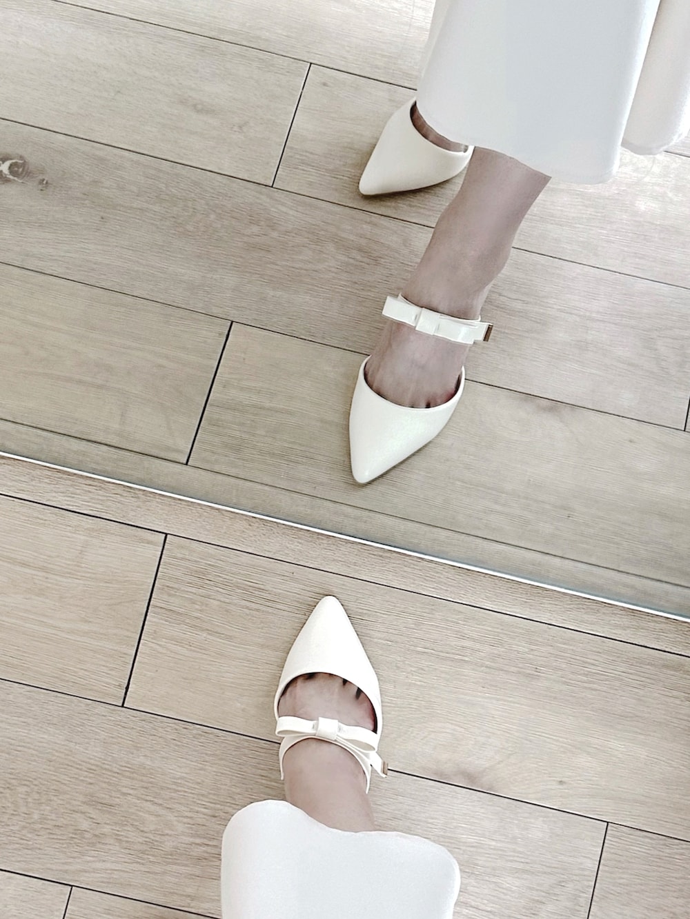 ホワイト系のパンプス、ホワイト系のスカート、ホワイト系のハンドバッグを着用したレディースの春コーディネートの5枚目の写真