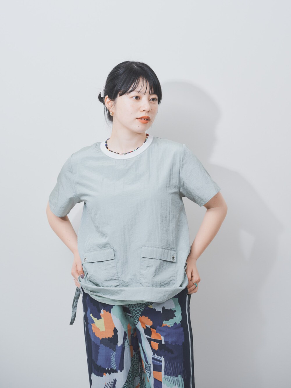 グリーン系のシャツ/ブラウスを着用したレディースの夏コーディネートの3枚目の写真