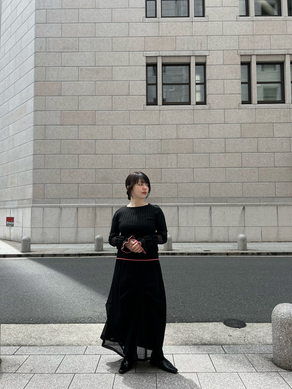 ブラック系のニット/セーター、ブラック系のスカートを着用したレディースの春コーディネートの4枚目の写真
