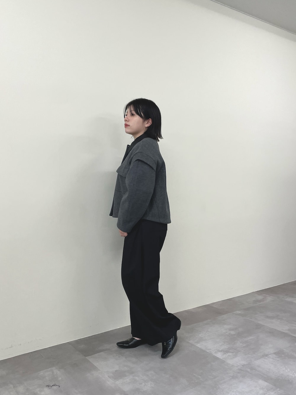 グレー系のミリタリージャケット、ブラック系のスラックスを着用したレディースの秋コーディネートの2枚目の写真