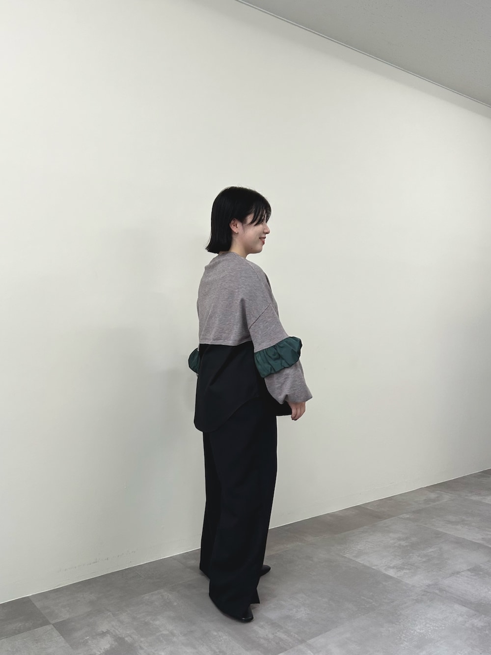 ブラウン系のニット/セーター、ブラック系のスラックスを着用したレディースの秋コーディネートの3枚目の写真