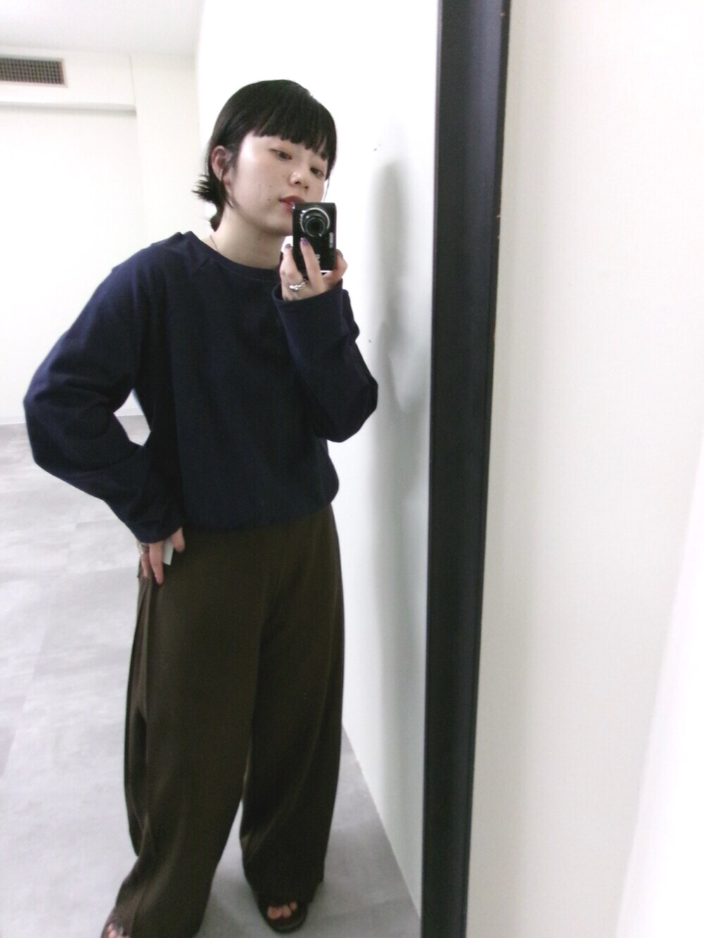 ブルー系のTシャツ/カットソー、ブラウン系のスラックスを着用したレディースの秋コーディネートの3枚目の写真