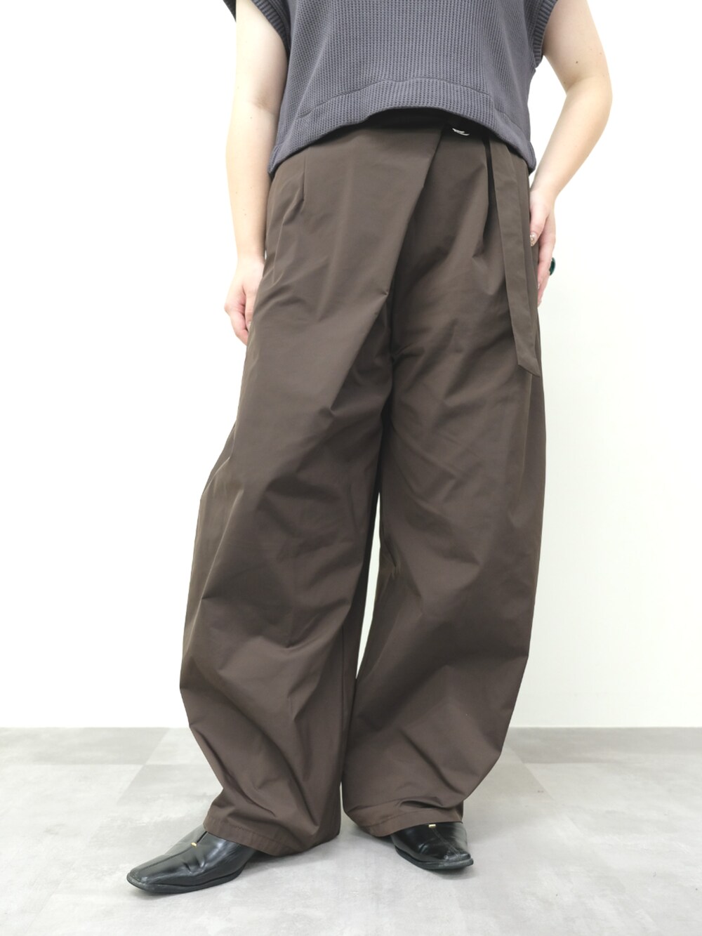 ブラウン系のベスト、ブラウン系のチノパンツを着用したレディースの秋コーディネートの2枚目の写真