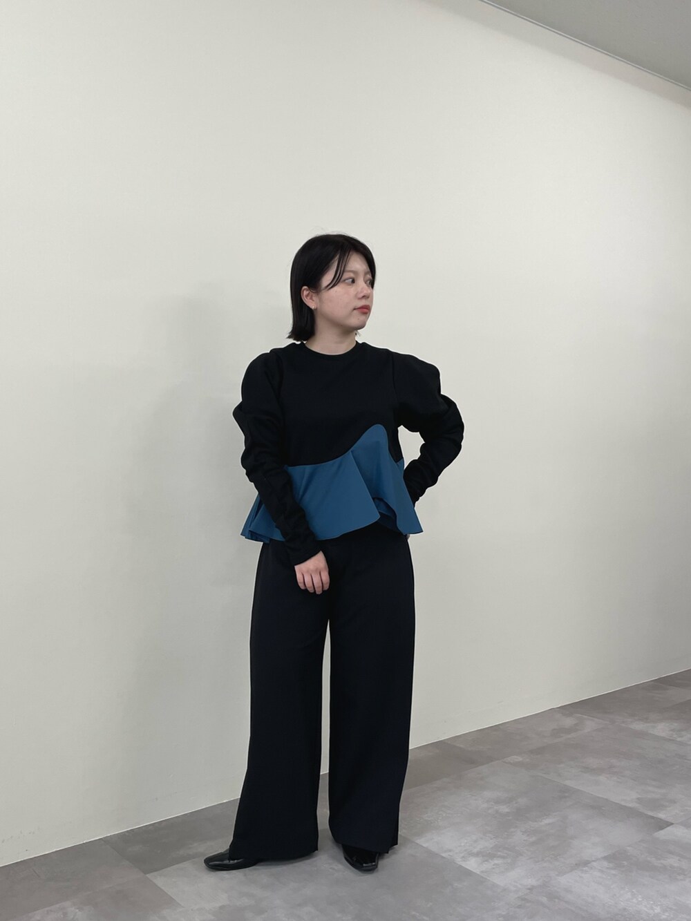 ブラック系のスウェット、ブラック系のスラックスを着用したレディースの秋コーディネートの2枚目の写真