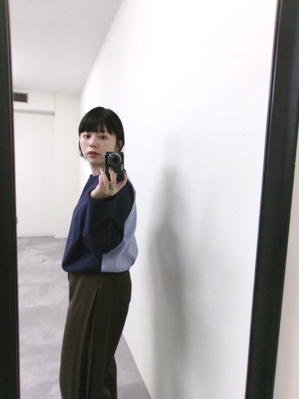 ブルー系のTシャツ/カットソー、ブラウン系のスラックスを着用したレディースの秋コーディネートの2枚目の写真