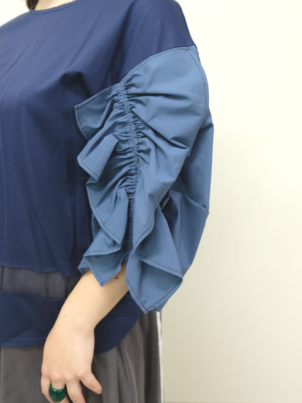 ブルー系のTシャツ/カットソー、グレー系のスカートを着用したレディースの秋コーディネートの2枚目の写真