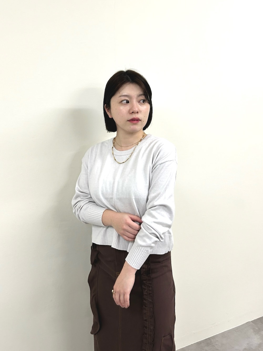 グレー系のニット/セーター、ブラウン系のスカートを着用したレディースの冬コーディネートの2枚目の写真