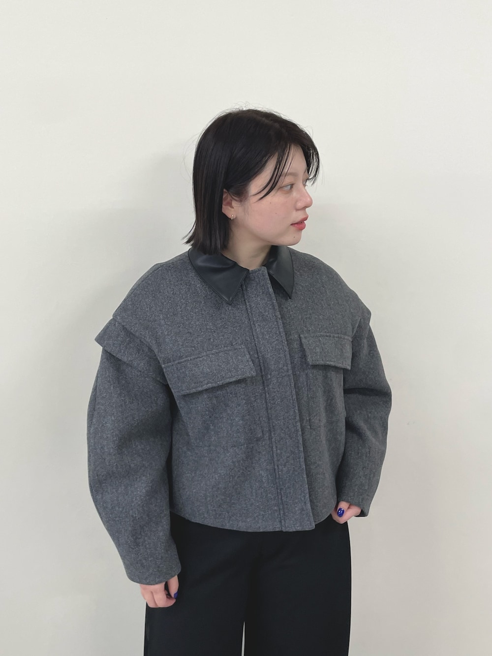 グレー系のミリタリージャケット、ブラック系のスラックスを着用したレディースの秋コーディネートの4枚目の写真