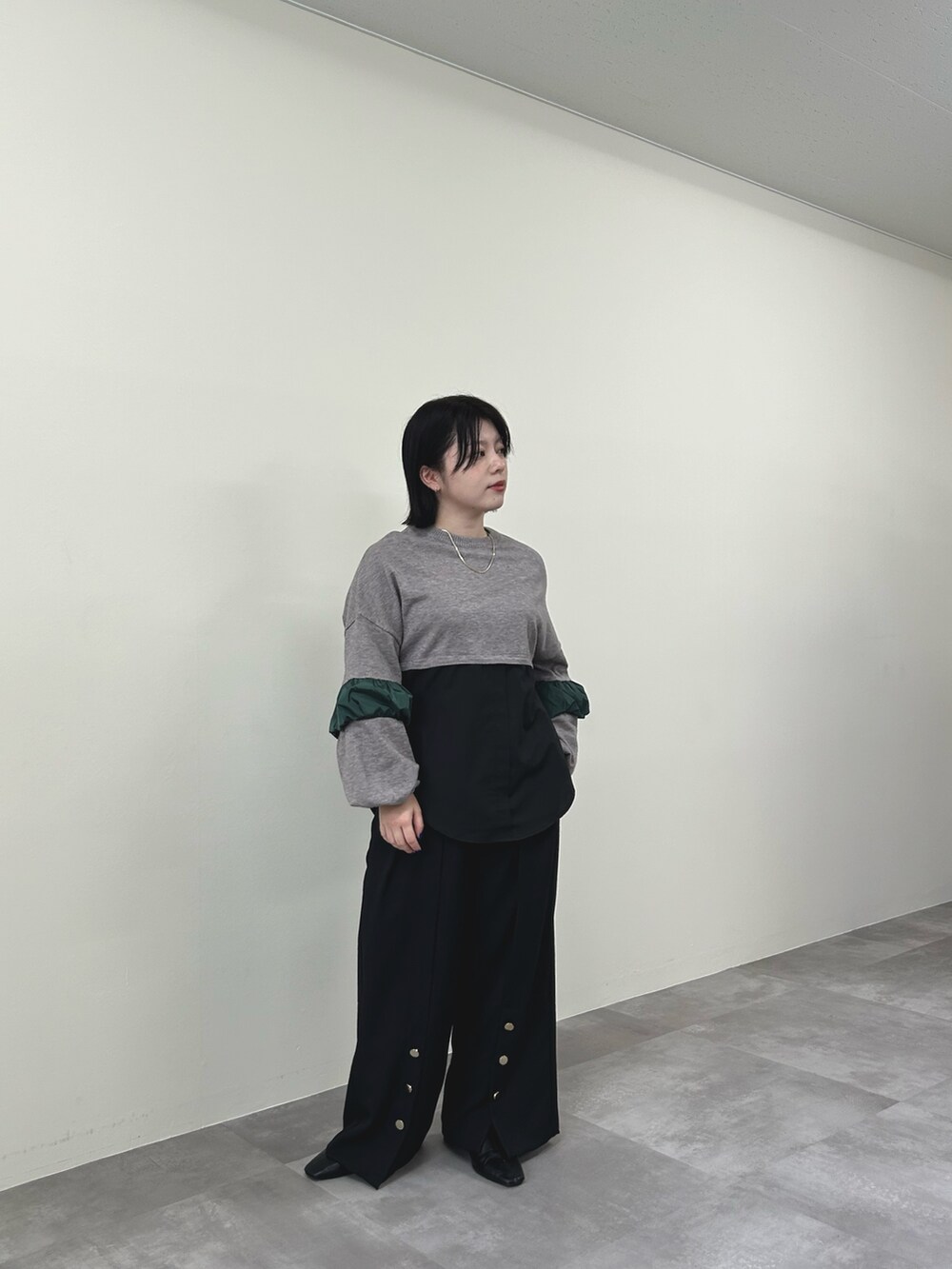 ブラウン系のニット/セーター、ブラック系のスラックスを着用したレディースの秋コーディネートの2枚目の写真