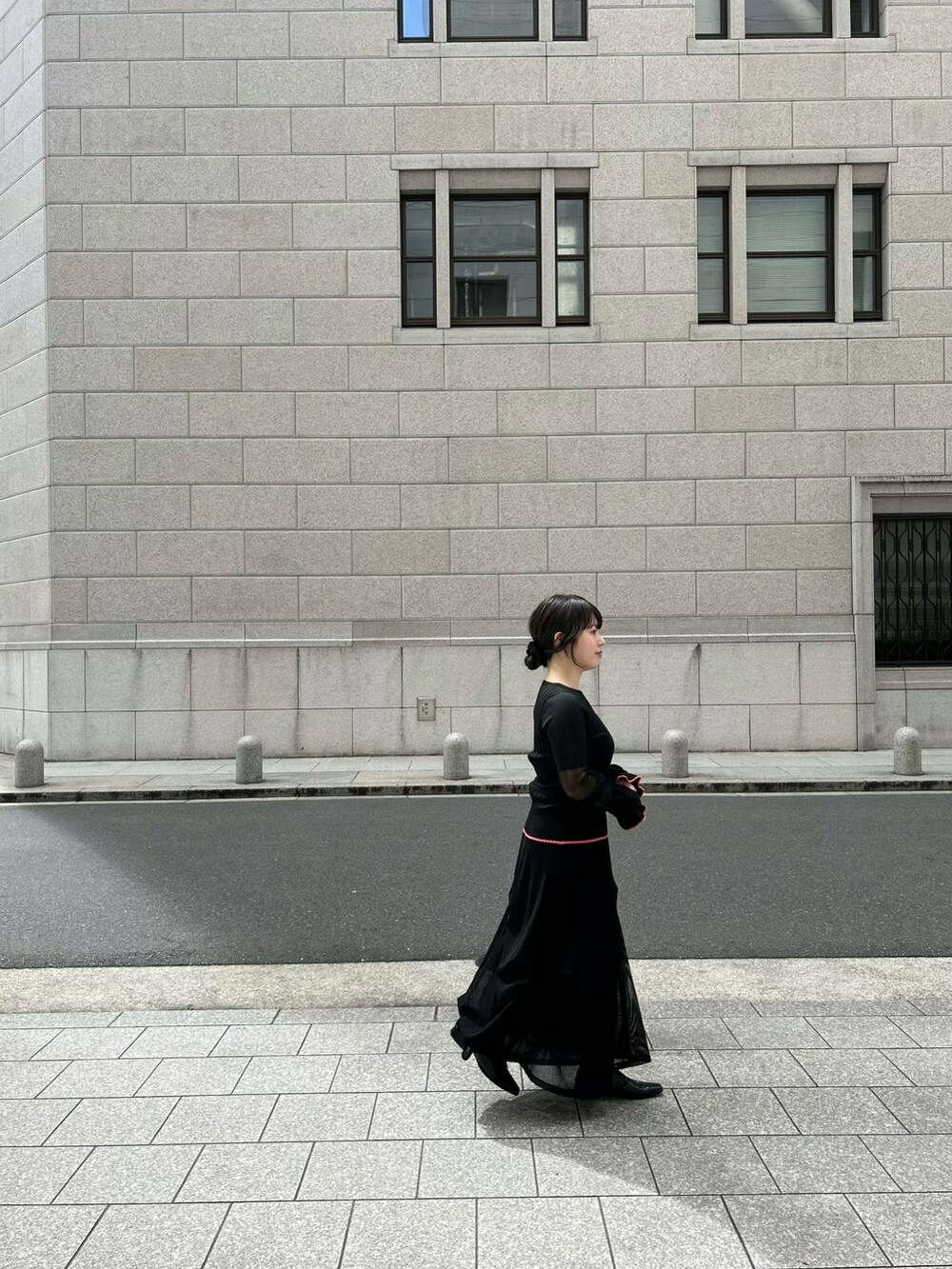 ブラック系のニット/セーター、ブラック系のスカートを着用したレディースの春コーディネートの3枚目の写真