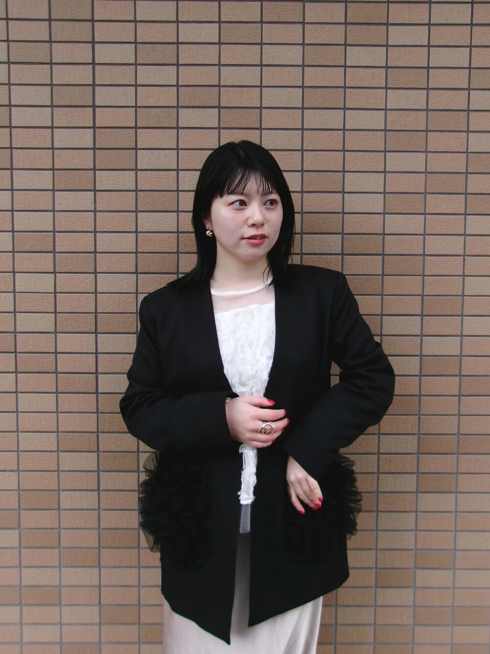 ブラック系のノーカラージャケット、ホワイト系のTシャツ/カットソーを着用したレディースの秋コーディネートの2枚目の写真