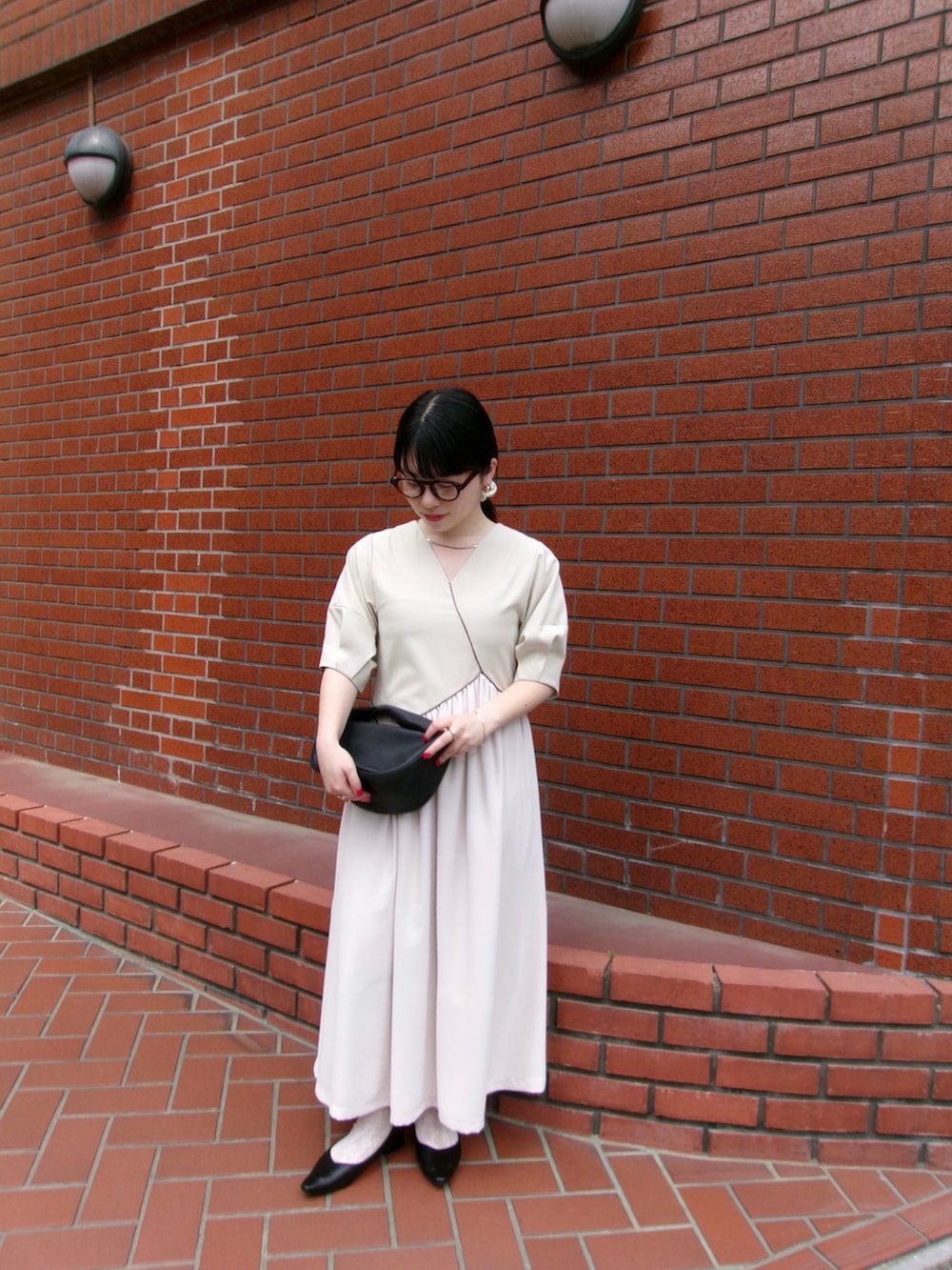 ベージュ系のワンピースを着用したレディースの春コーディネートの2枚目の写真