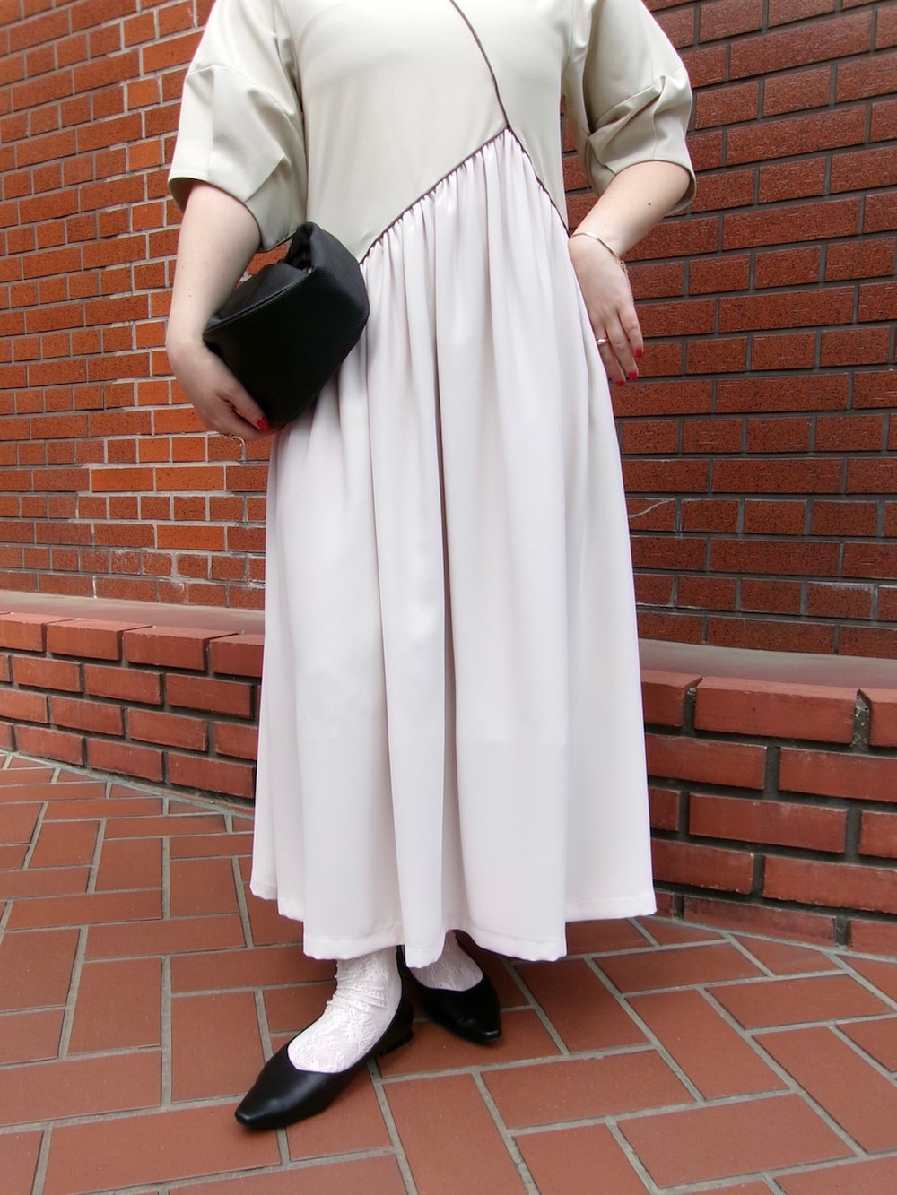 ベージュ系のワンピースを着用したレディースの春コーディネートの3枚目の写真