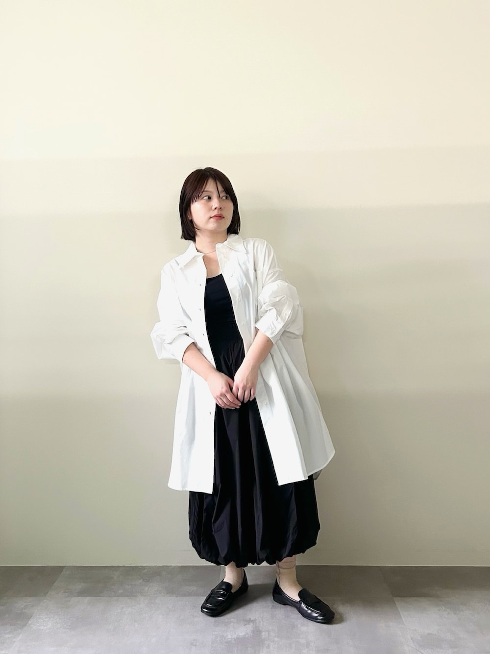 ホワイト系のシャツ/ブラウス、ブラック系のスカートを着用したレディースの春コーディネートの2枚目の写真