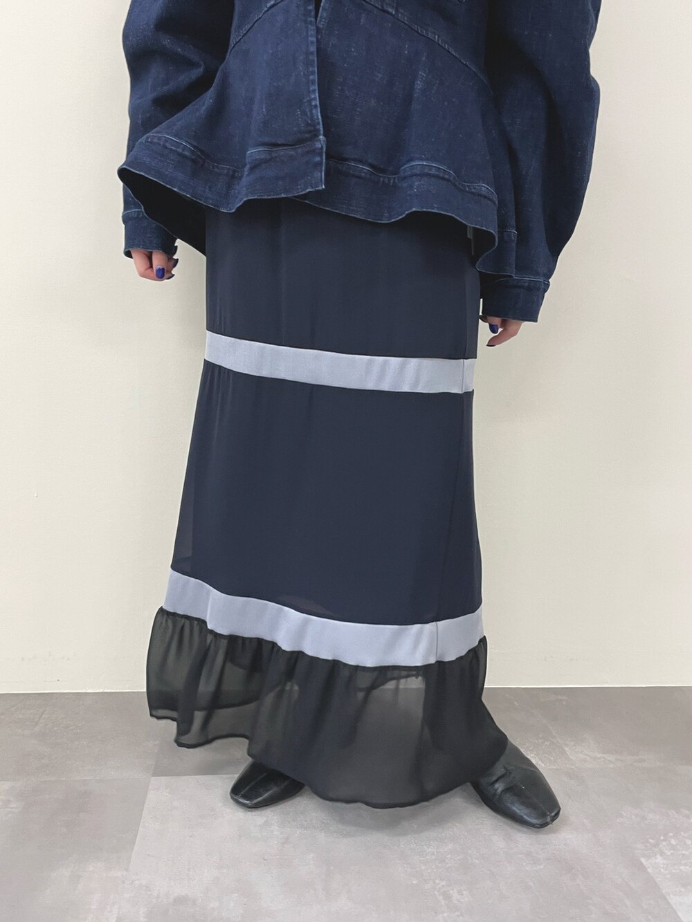 ブルー系のデニムジャケット、ブラック系のその他トップス、ブルー系のスカートを着用したレディースの秋コーディネートの3枚目の写真