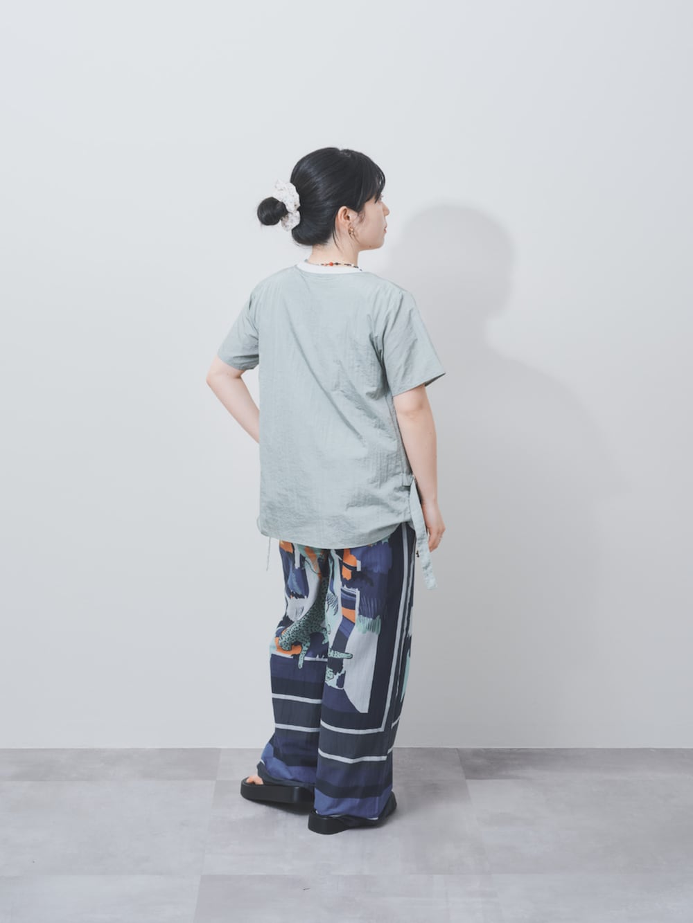 グリーン系のシャツ/ブラウスを着用したレディースの夏コーディネートの2枚目の写真