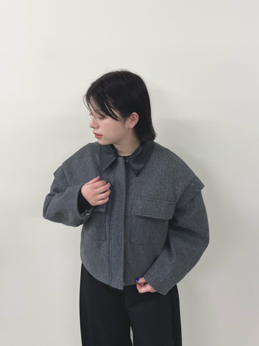 グレー系のミリタリージャケット、ブラック系のスラックスを着用したレディースの秋コーディネートの3枚目の写真