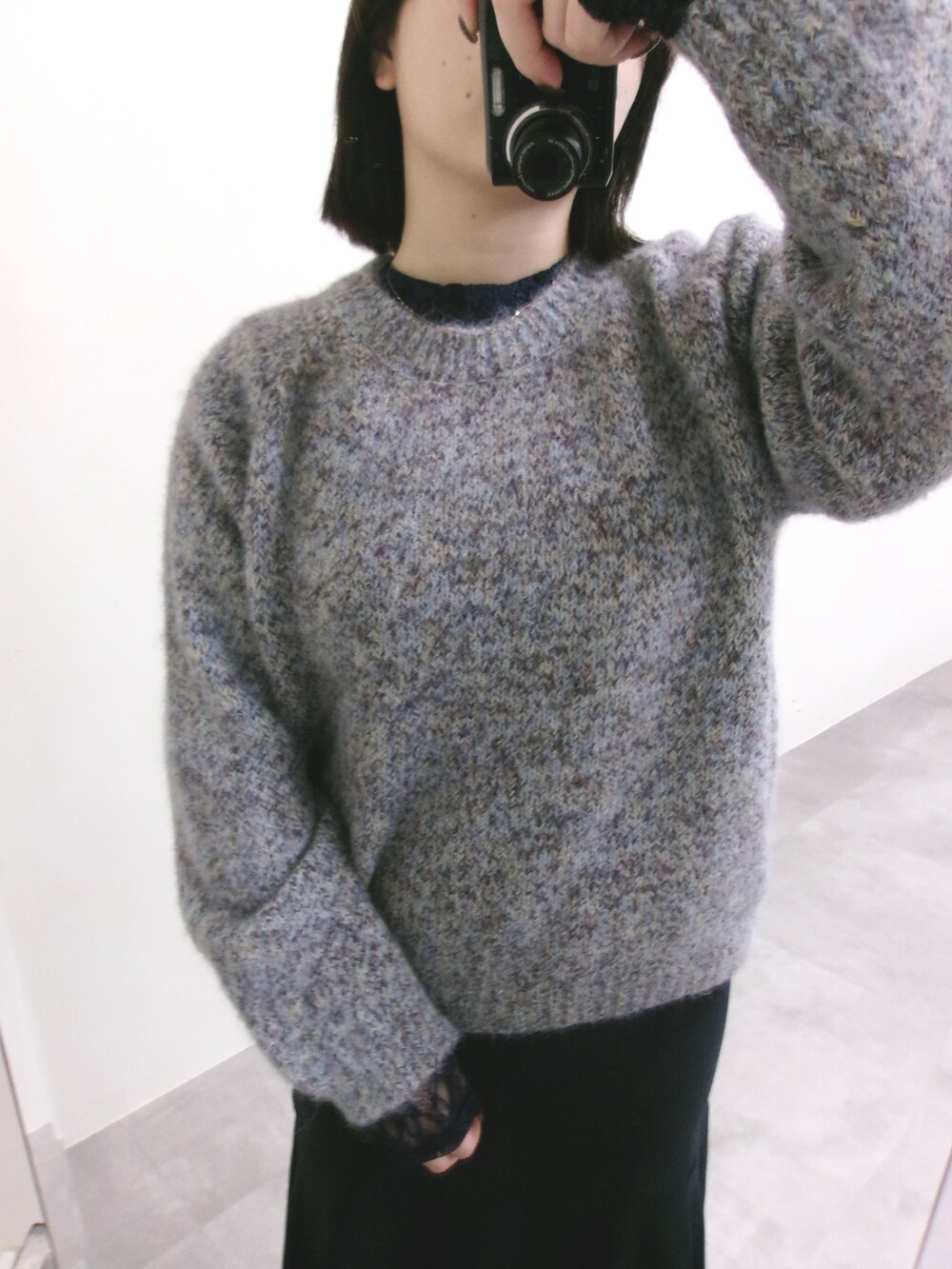 パープル系のニット/セーター、ブラック系のTシャツ/カットソー、ブルー系のスカートを着用したレディースの冬コーディネートの2枚目の写真