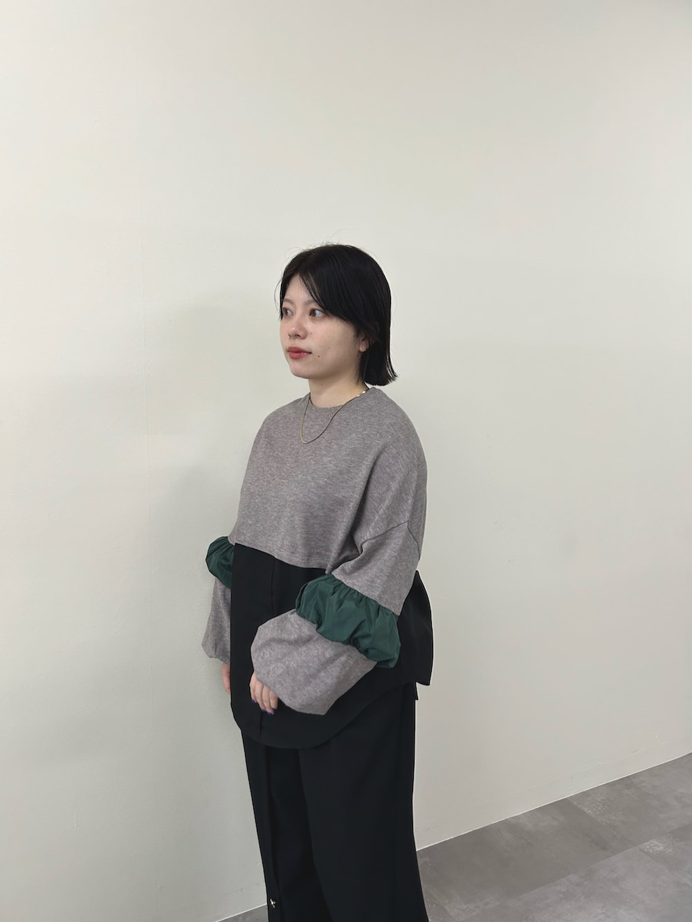 ブラウン系のニット/セーター、ブラック系のスラックスを着用したレディースの秋コーディネートの4枚目の写真