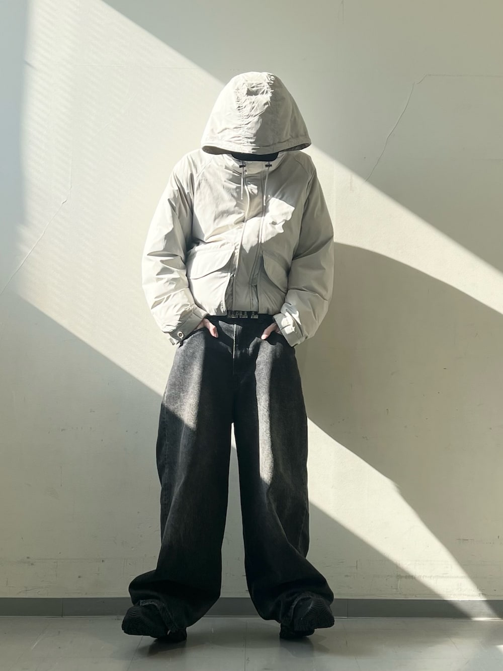 ベージュ系のブルゾン、ブラック系のスニーカー、ブラック系のデニムパンツを着用したメンズの秋コーディネートの2枚目の写真