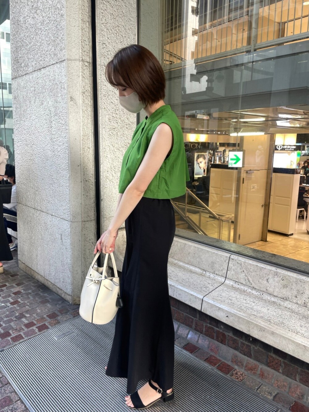 ホワイト系のハンドバッグ、グリーン系のシャツ/ブラウス、ブラック系のスカートを着用したレディースの夏コーディネートの2枚目の写真