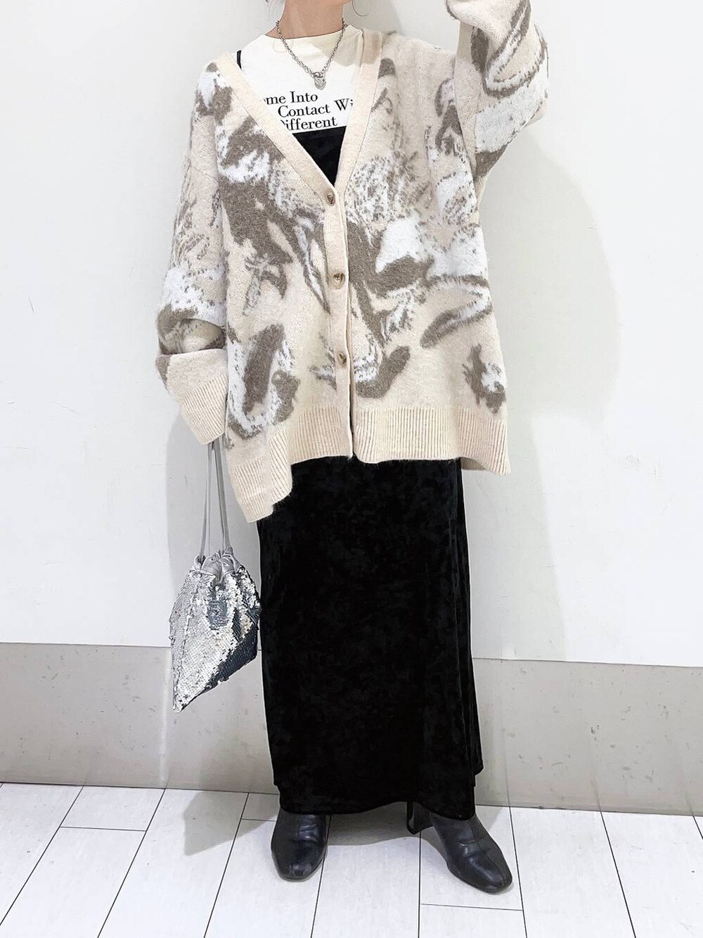 ブラック系のブーツ、グレー系のワンピース、シルバー系のハンドバッグを着用したレディースの冬コーディネートの3枚目の写真