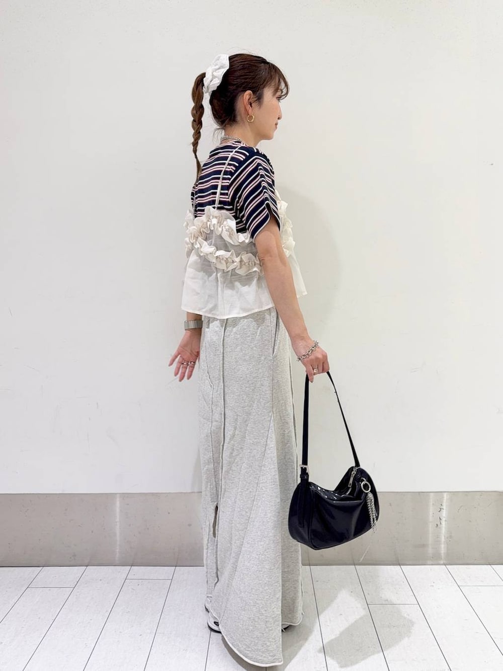 ブルー系のTシャツ/カットソー、ホワイト系のキャミソール、ブラック系のトートバッグを着用したレディースの春コーディネートの2枚目の写真