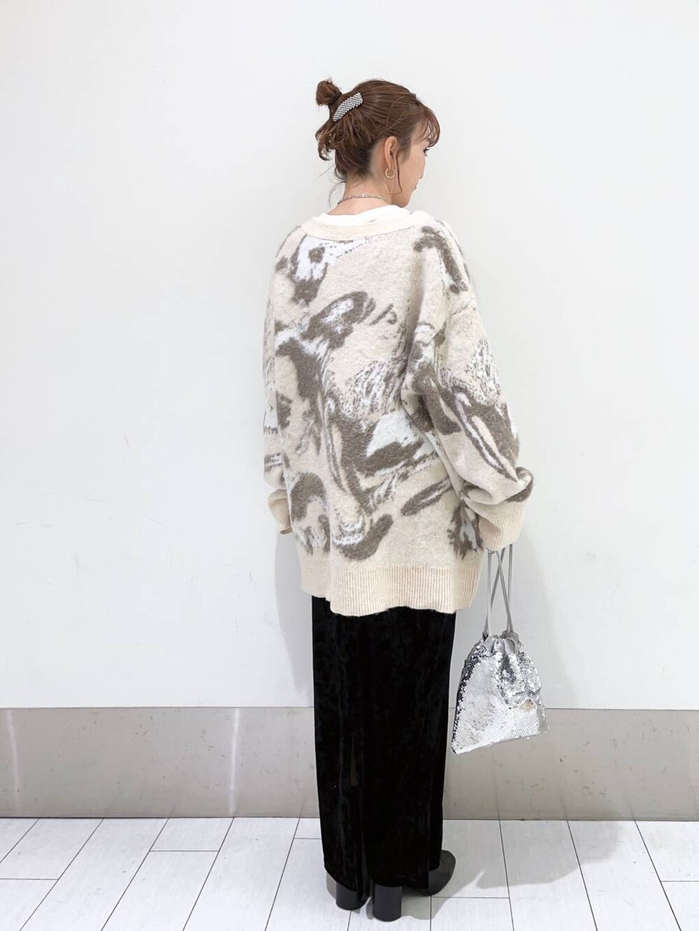 ブラック系のブーツ、グレー系のワンピース、シルバー系のハンドバッグを着用したレディースの冬コーディネートの2枚目の写真