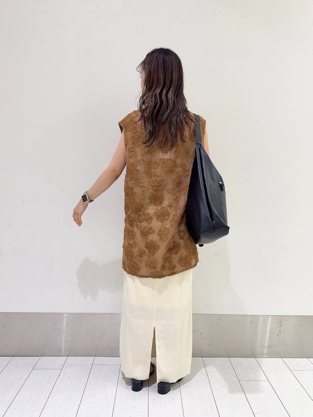 ホワイト系のスカート、ブラック系のショルダーバッグ、ホワイト系のキャミソールを着用したレディースの夏コーディネートの3枚目の写真