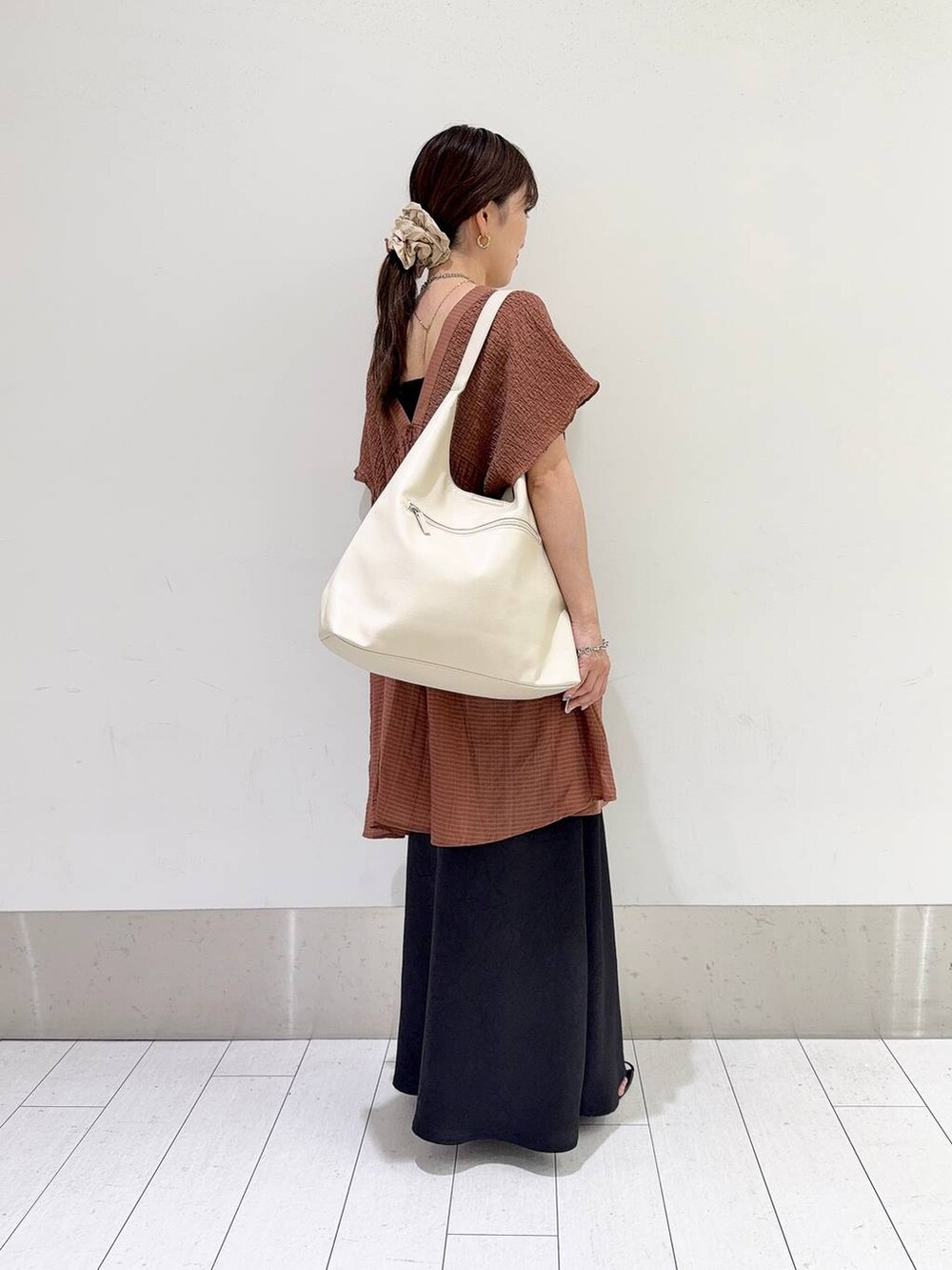 ホワイト系のショルダーバッグ、ブラック系のスカート、ブラウン系のシャツ/ブラウスを着用したレディースの夏コーディネートの3枚目の写真