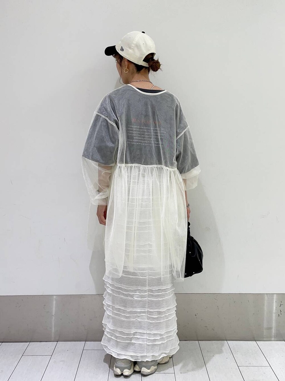 ブラック系のハンドバッグ、ホワイト系のスカート、ホワイト系のシャツ/ブラウスを着用したレディースの春コーディネートの2枚目の写真