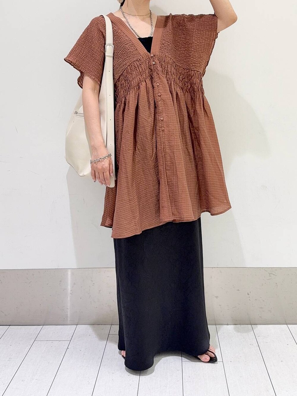 ホワイト系のショルダーバッグ、ブラック系のスカート、ブラウン系のシャツ/ブラウスを着用したレディースの夏コーディネートの5枚目の写真