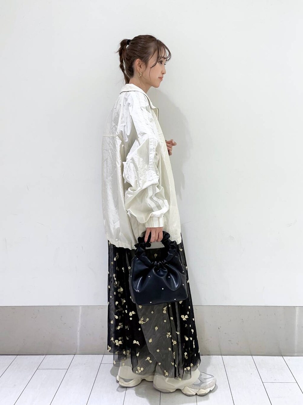 ブラック系のハンドバッグ、ホワイト系のスラックス、その他のワンピースを着用したレディースの春コーディネートの2枚目の写真