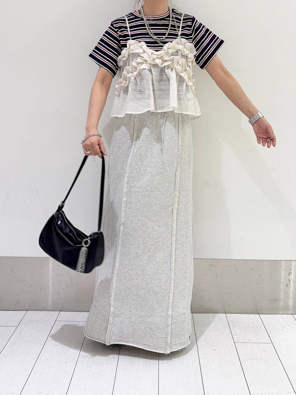 ブルー系のTシャツ/カットソー、ホワイト系のキャミソール、ブラック系のトートバッグを着用したレディースの春コーディネートの5枚目の写真