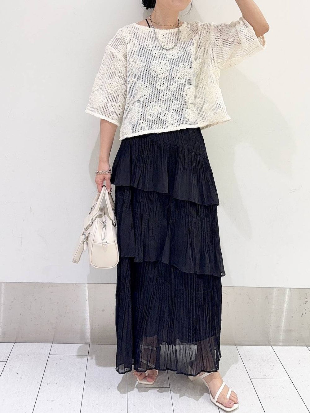 ホワイト系のサンダル、ブラック系のスカート、ホワイト系のショルダーバッグを着用したレディースの夏コーディネートの4枚目の写真