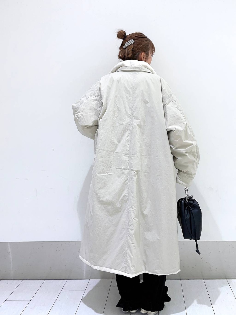 ホワイト系のTシャツ/カットソー、ホワイト系のミリタリージャケット、ブラック系のショルダーバッグを着用したレディースの秋コーディネートの2枚目の写真