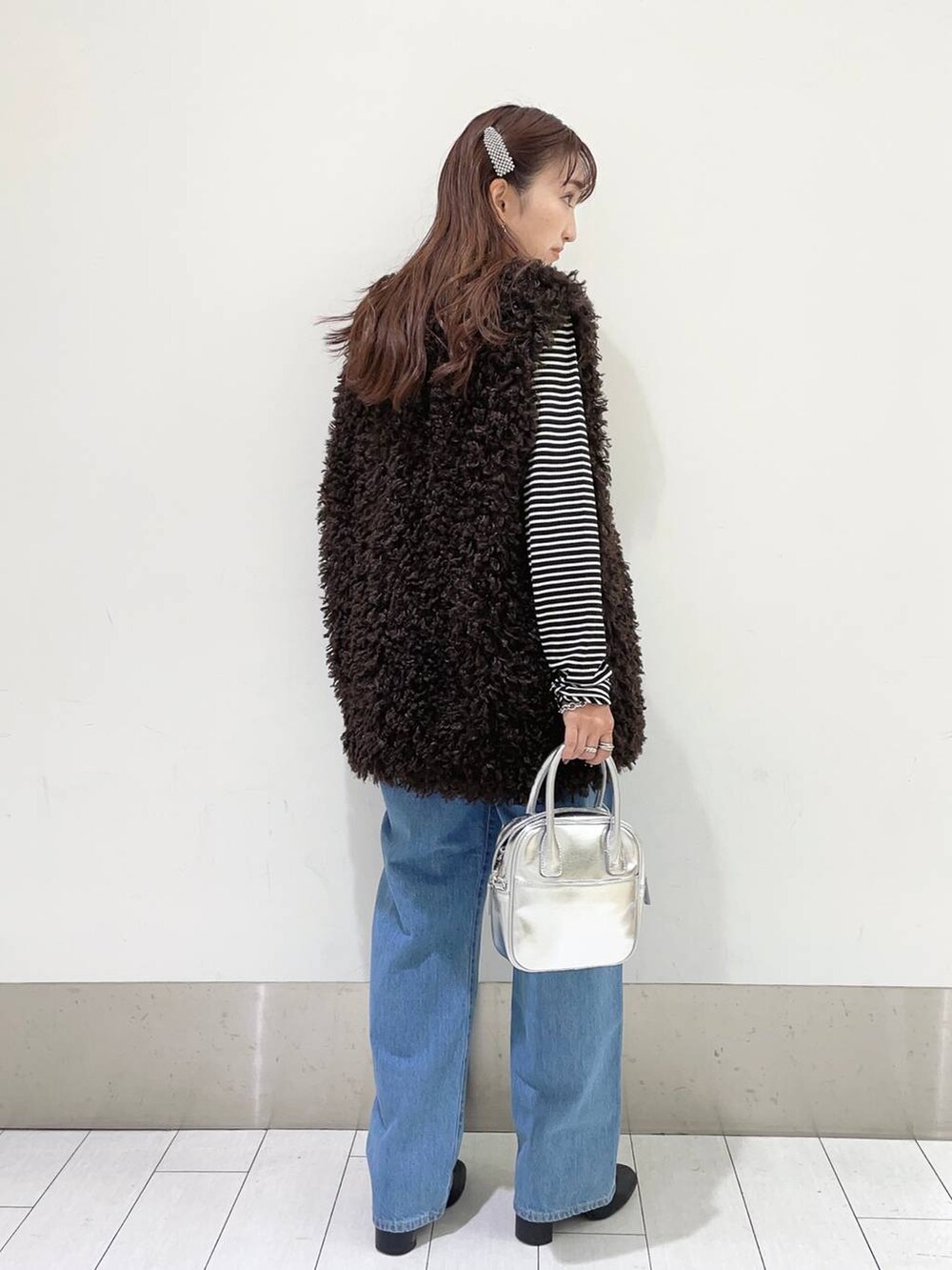 ブラック系のTシャツ/カットソー、ブルー系のデニムパンツ、ブラック系のブーツを着用したレディースの秋コーディネートの2枚目の写真