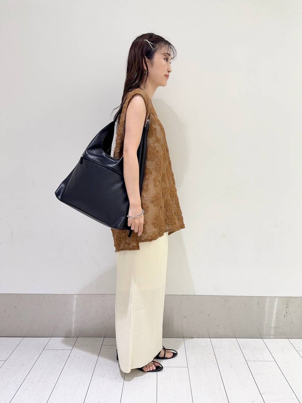 ホワイト系のスカート、ブラック系のショルダーバッグ、ホワイト系のキャミソールを着用したレディースの夏コーディネートの2枚目の写真