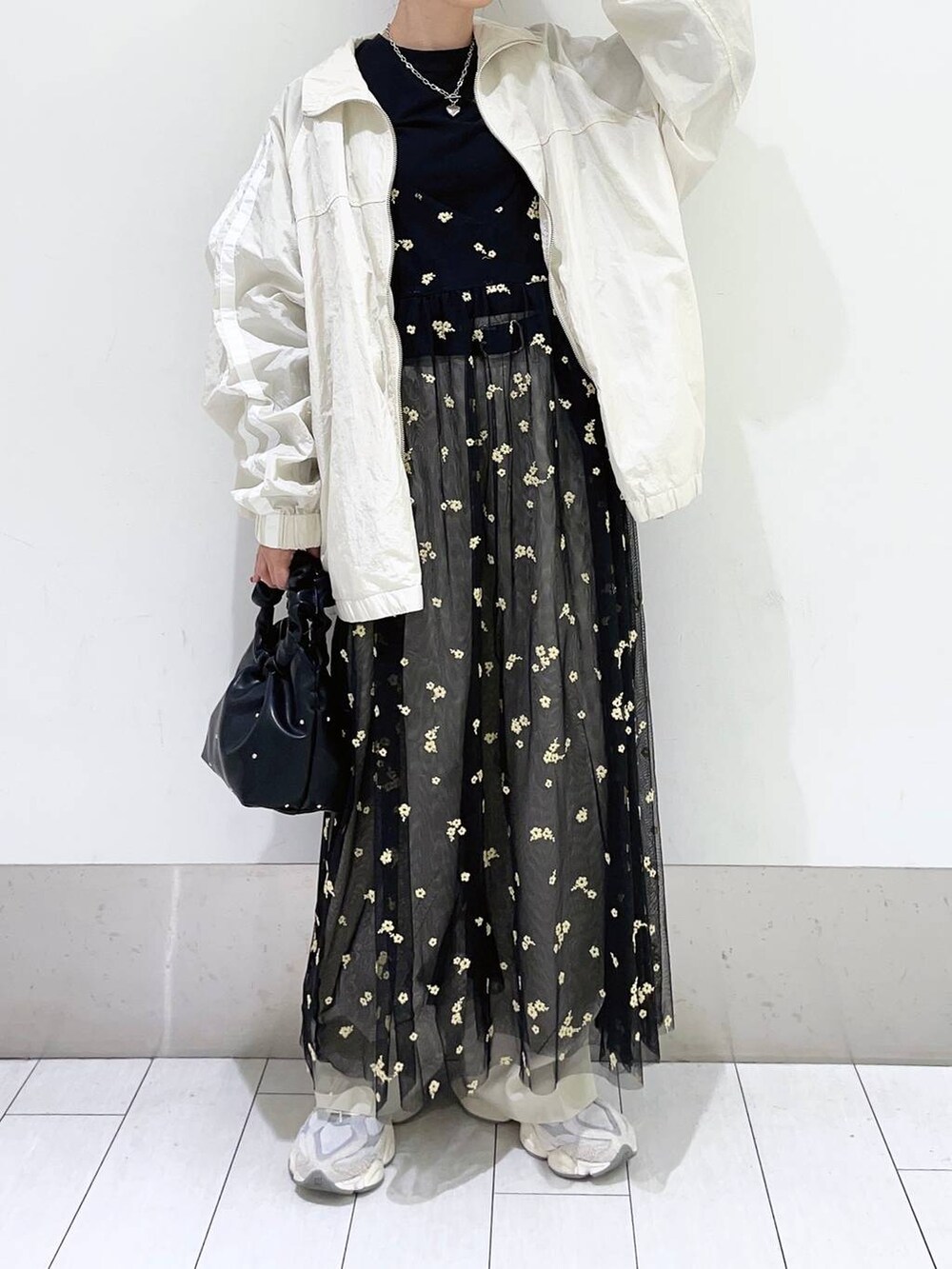 ブラック系のハンドバッグ、ホワイト系のスラックス、その他のワンピースを着用したレディースの春コーディネートの3枚目の写真