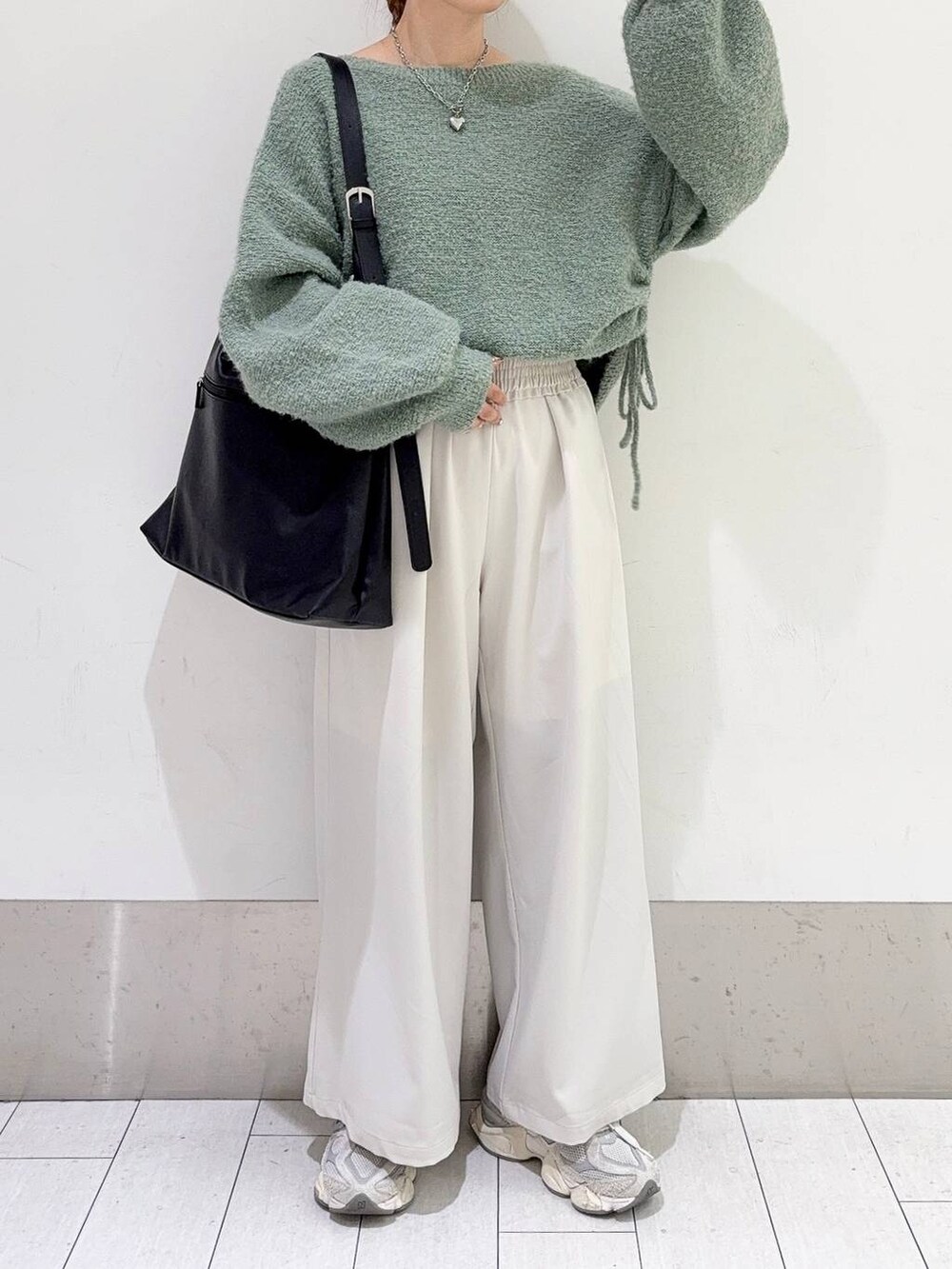 ブラック系のショルダーバッグ、ホワイト系のその他パンツ、グリーン系のニット/セーターを着用したレディースの冬コーディネートの3枚目の写真