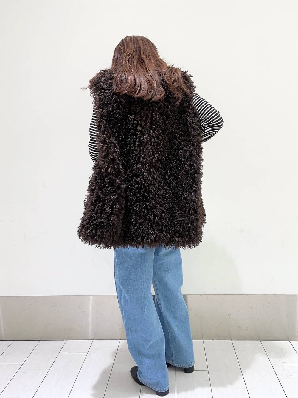 ブラック系のTシャツ/カットソー、ブルー系のデニムパンツ、ブラック系のブーツを着用したレディースの秋コーディネートの3枚目の写真