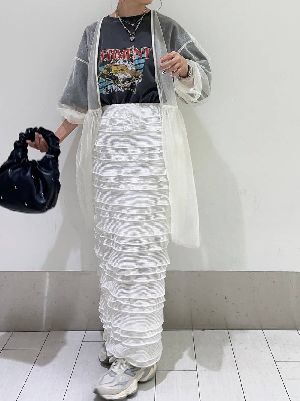 ブラック系のハンドバッグ、ホワイト系のスカート、ホワイト系のシャツ/ブラウスを着用したレディースの春コーディネートの3枚目の写真