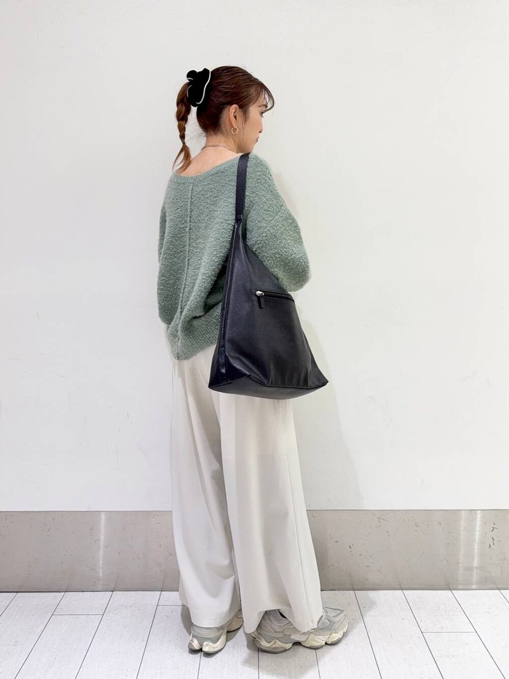 ブラック系のショルダーバッグ、ホワイト系のその他パンツ、グリーン系のニット/セーターを着用したレディースの冬コーディネートの2枚目の写真