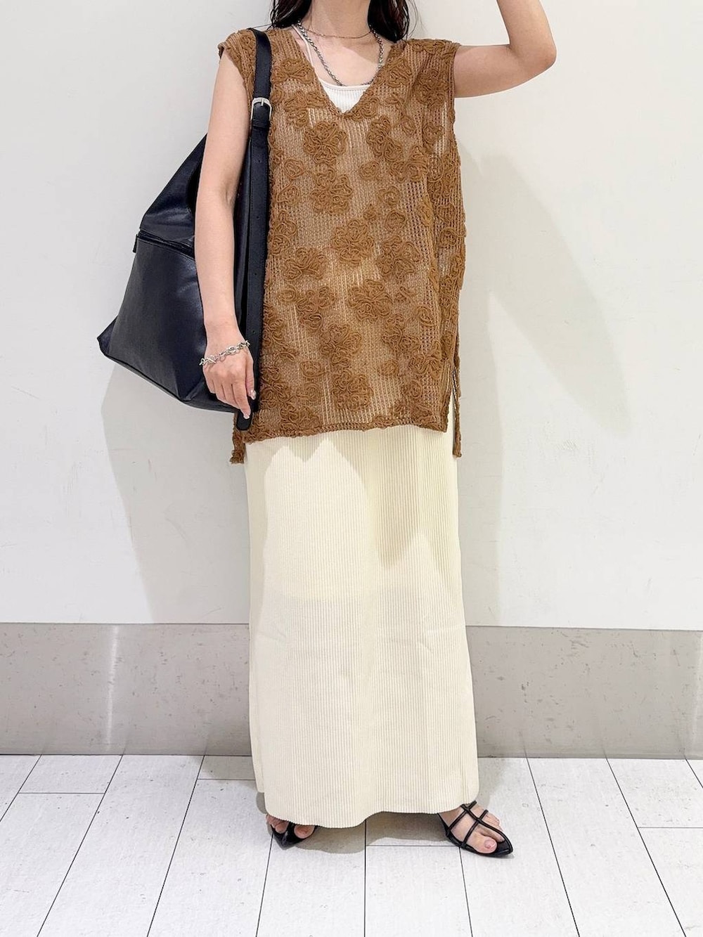 ホワイト系のスカート、ブラック系のショルダーバッグ、ホワイト系のキャミソールを着用したレディースの夏コーディネートの4枚目の写真