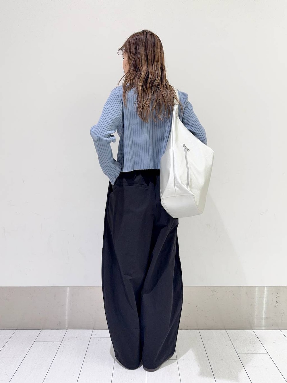 ブルー系のカーディガン/ボレロ、シルバー系のトートバッグ、ブラック系のスラックスを着用したレディースの春コーディネートの3枚目の写真