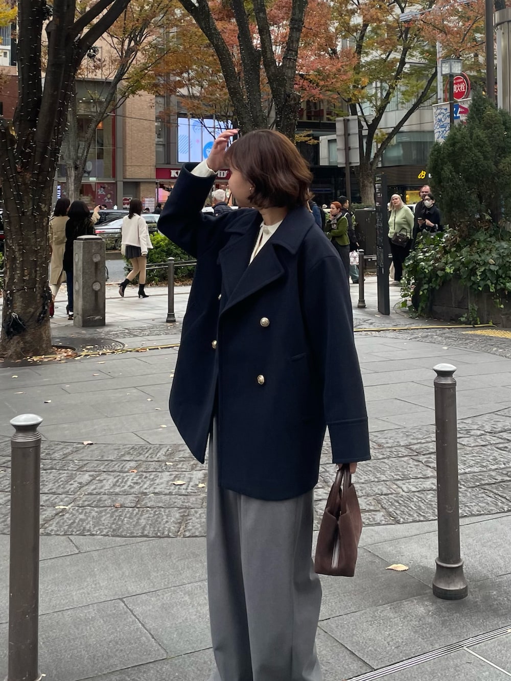 ブルー系のピーコート、グレー系のその他パンツ、ホワイト系のニット/セーターを着用したレディースの秋コーディネートの6枚目の写真