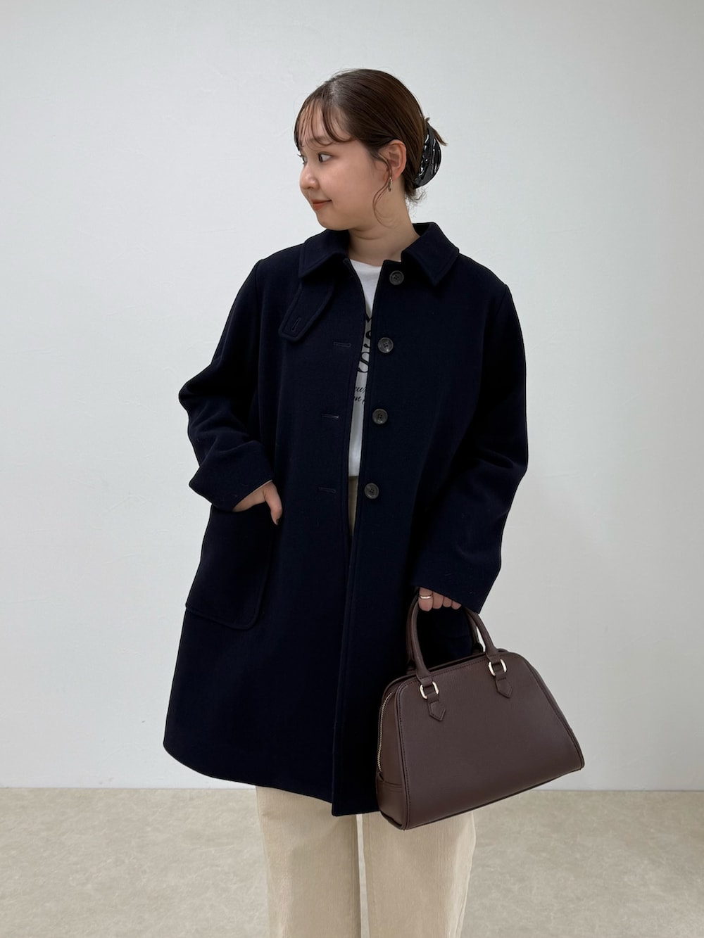 ブルー系のダッフルコート、ベージュ系のその他パンツ、ブラウン系のショルダーバッグを着用したレディースの秋コーディネートの6枚目の写真