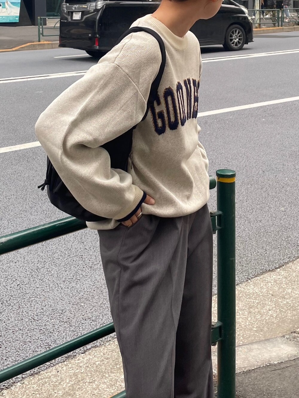 グレー系のその他パンツ、ホワイト系のニット/セーター、ブラック系のショルダーバッグを着用したレディースの冬コーディネートの3枚目の写真