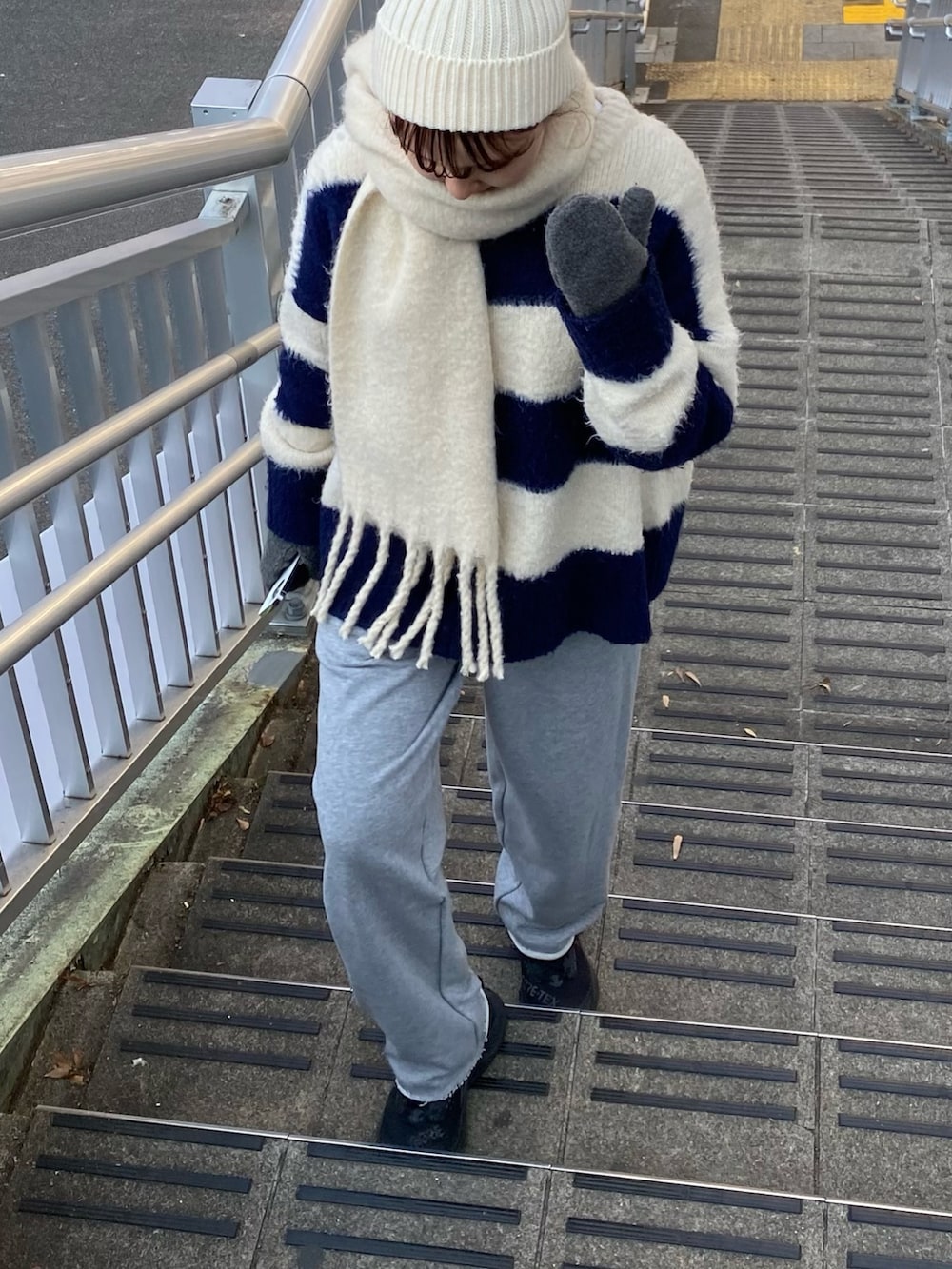 グレー系のスウェットパンツ、ホワイト系のマフラーを着用したレディースの冬コーディネートの6枚目の写真
