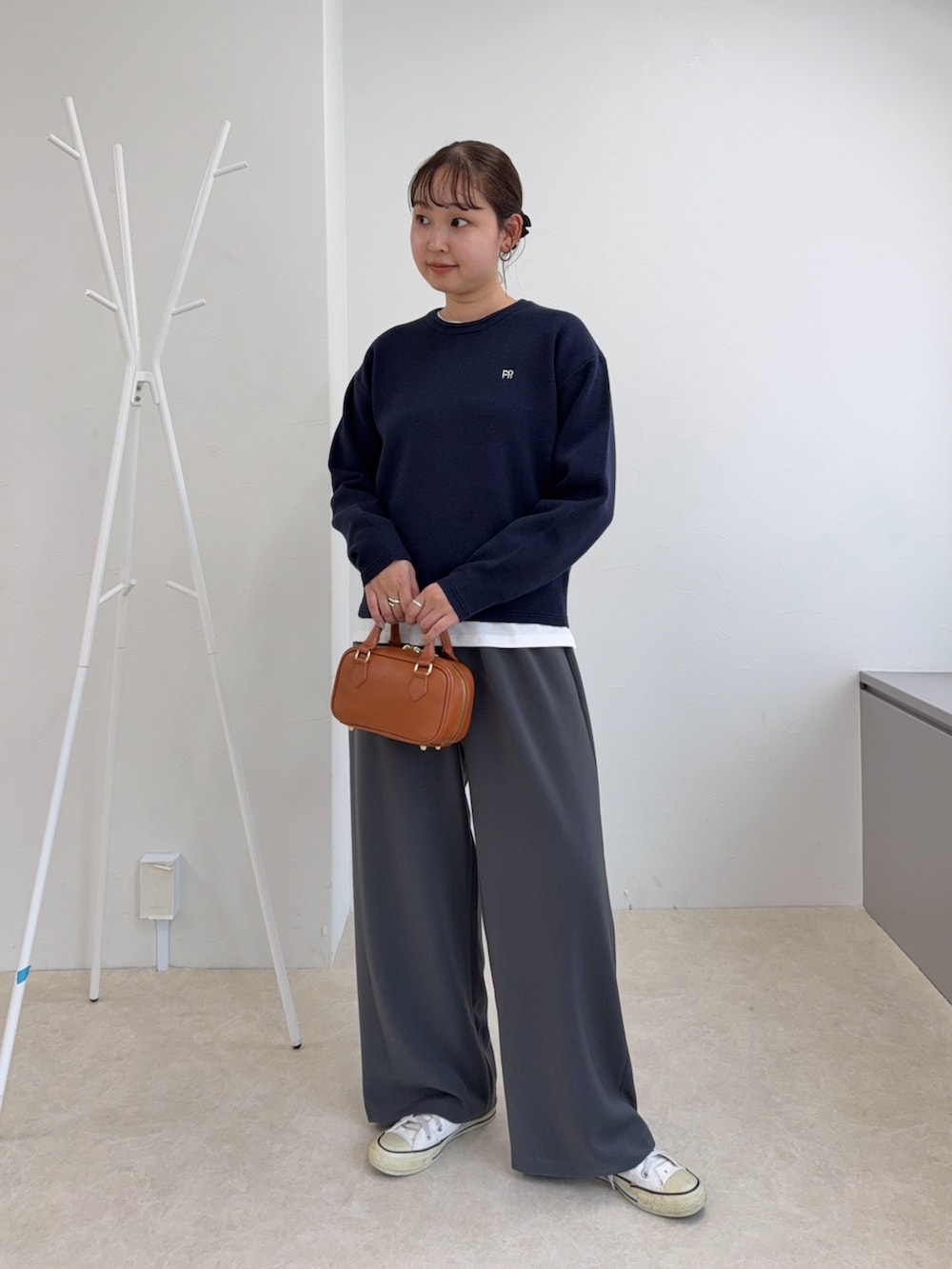 ブルー系のニット/セーター、グレー系のその他パンツ、イエロー系のショルダーバッグを着用したレディースの秋コーディネートの6枚目の写真
